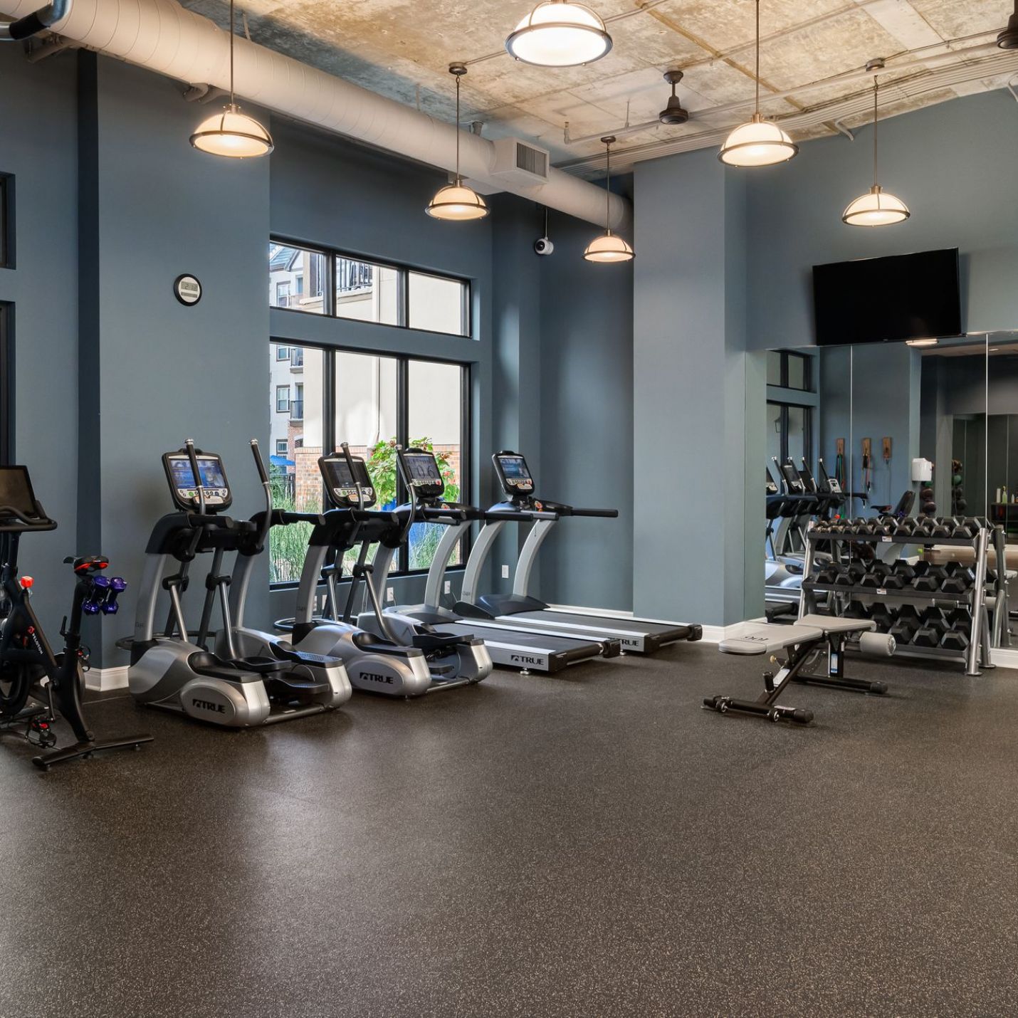 Mission 106 Luxury Apartments fitness center with exercise machines, a wall-mounted TV, and fitness equipment