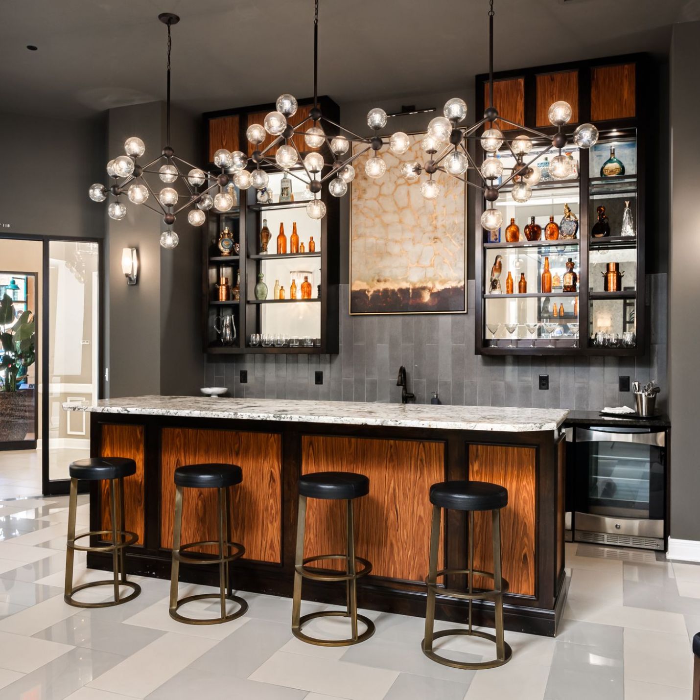 Mission 106 Luxury Apartments community amenties with a beautiful bar, bar stools, and elegant lighting