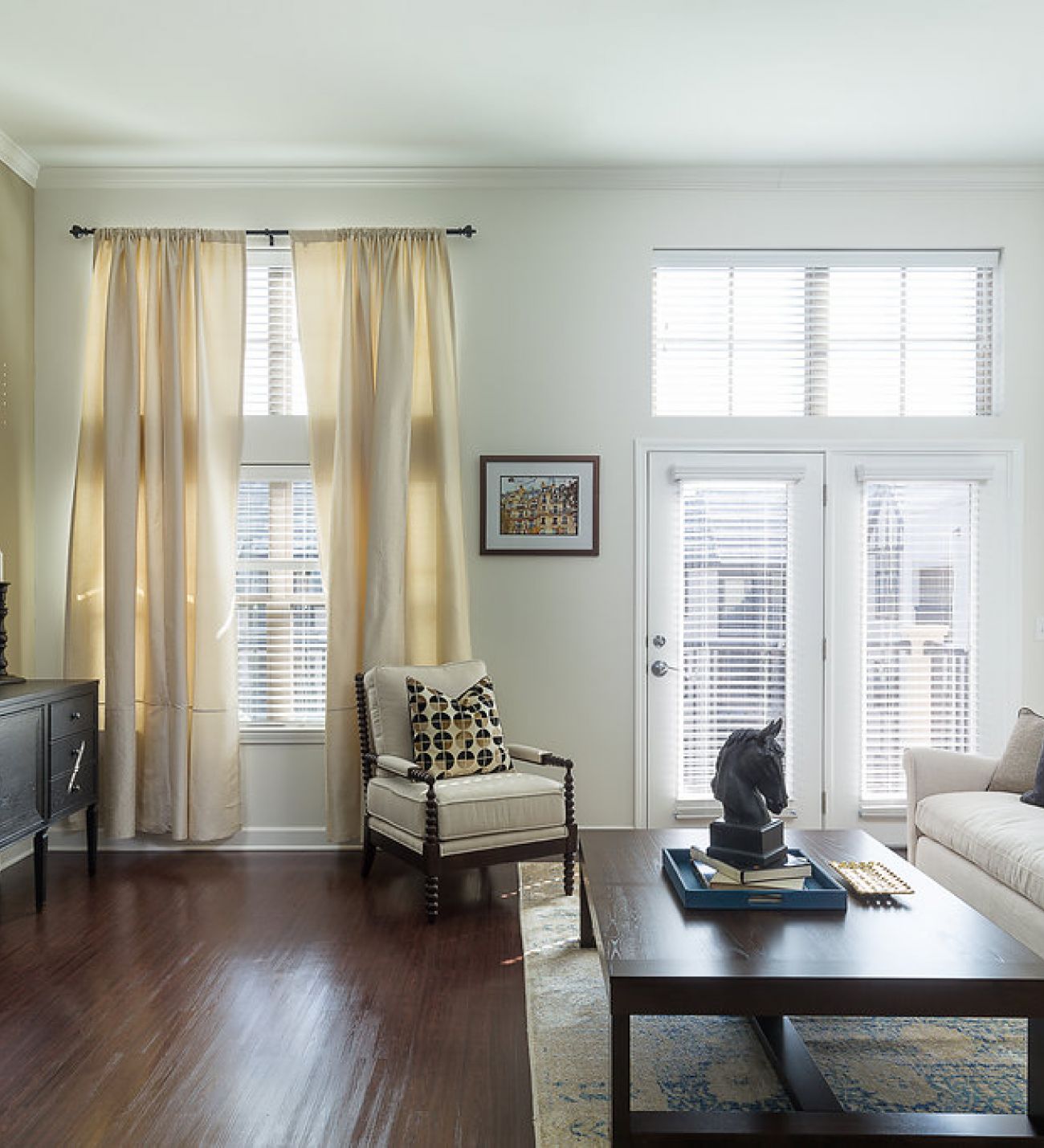 Mission 106 Luxury Apartments living room with a couch, coffee table, chair, rug, and floor-to-ceiling windows